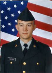 A picture of scott in his dress army uniform, with the stars and stripes as the back drop.